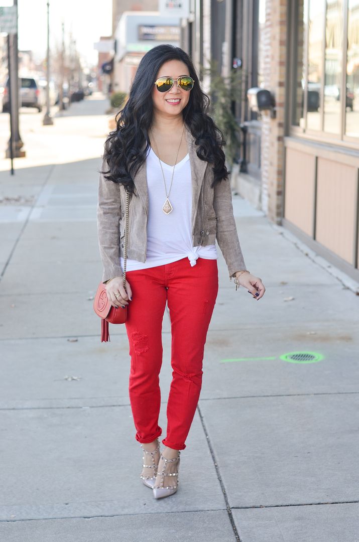 Neutral moto jacket, white tee, and red jeans outfit